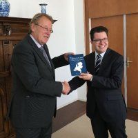 Richard van Oevelen overhandigt zijn boek aan de Commissaris van de Koning