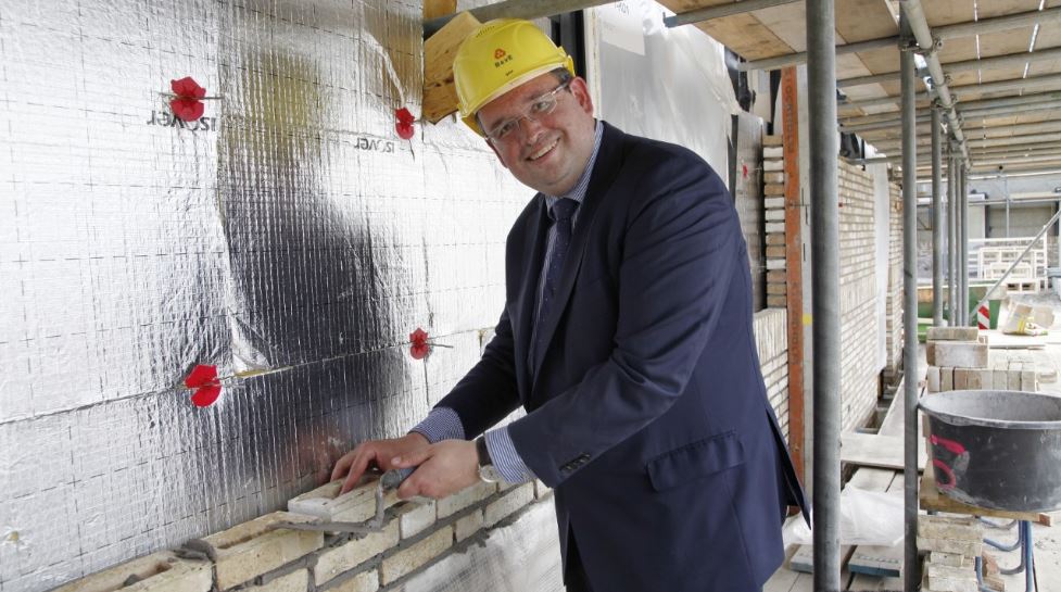 Wethouder Ronald van der Meij aan het werk als metselaar