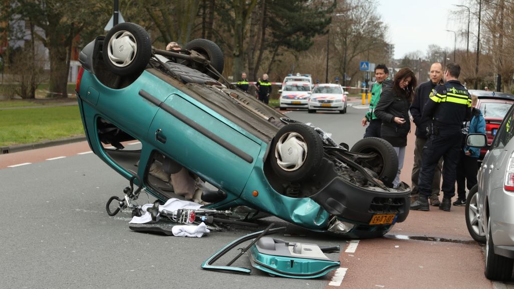Auto over de kop na botsing raakt fietser