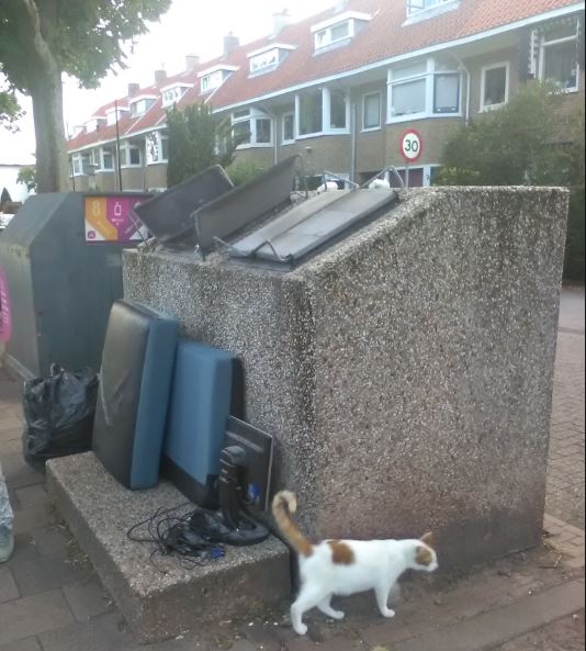 Computerscherm en kussens naast de afvalcontainer