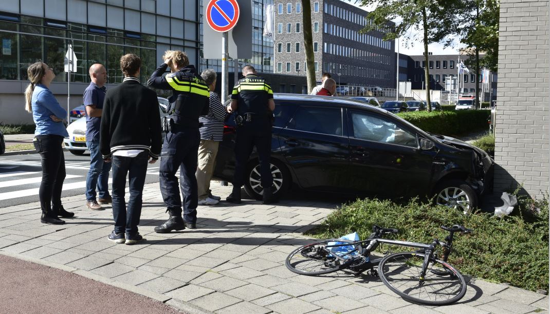 CD-Auto wijkt uit voor fietser en botst tegen gevel