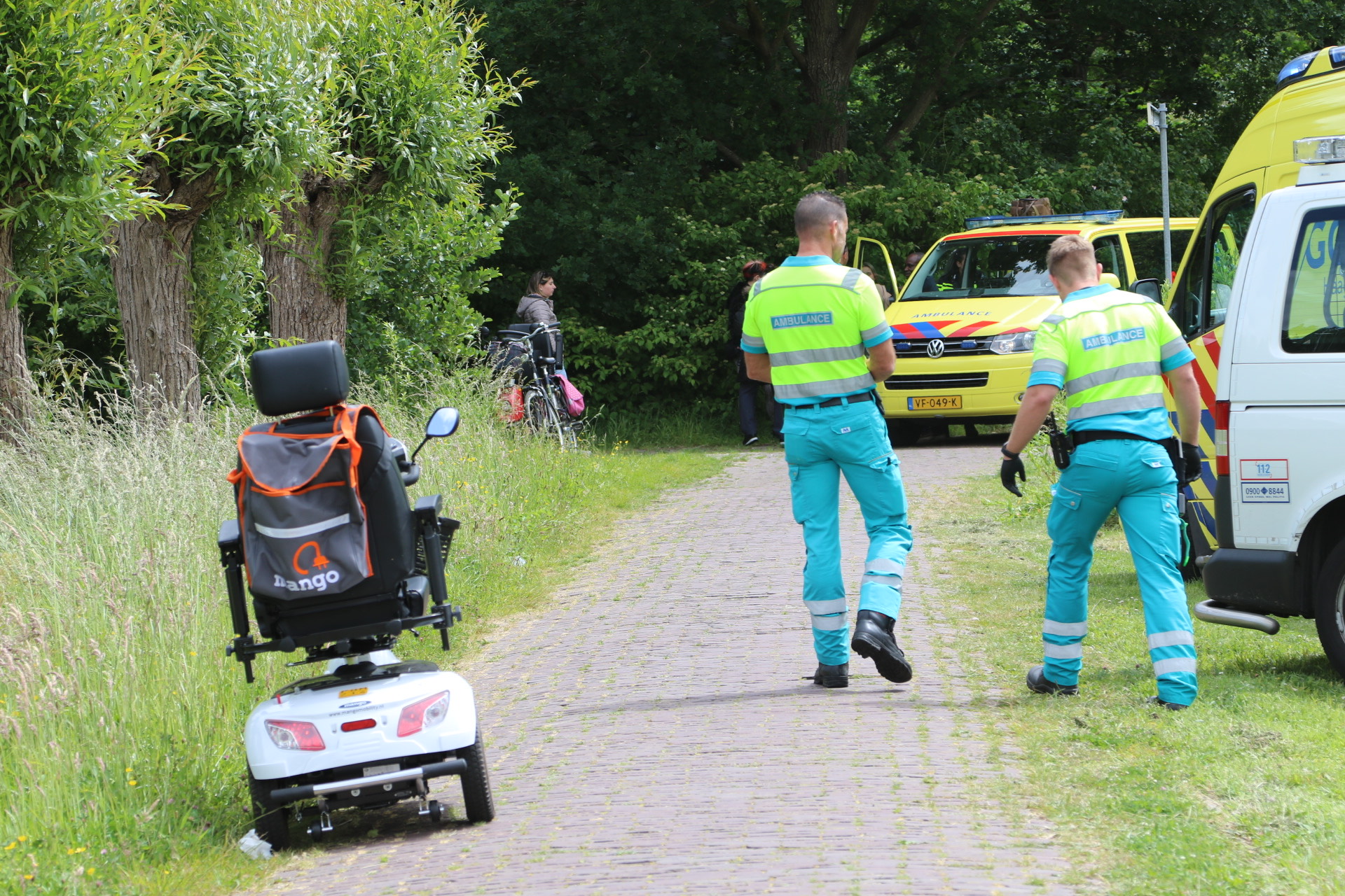 Vrouw met scootmobiel rijdt het water in