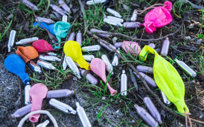 metal bulbs laughing gas and balloons in grass field