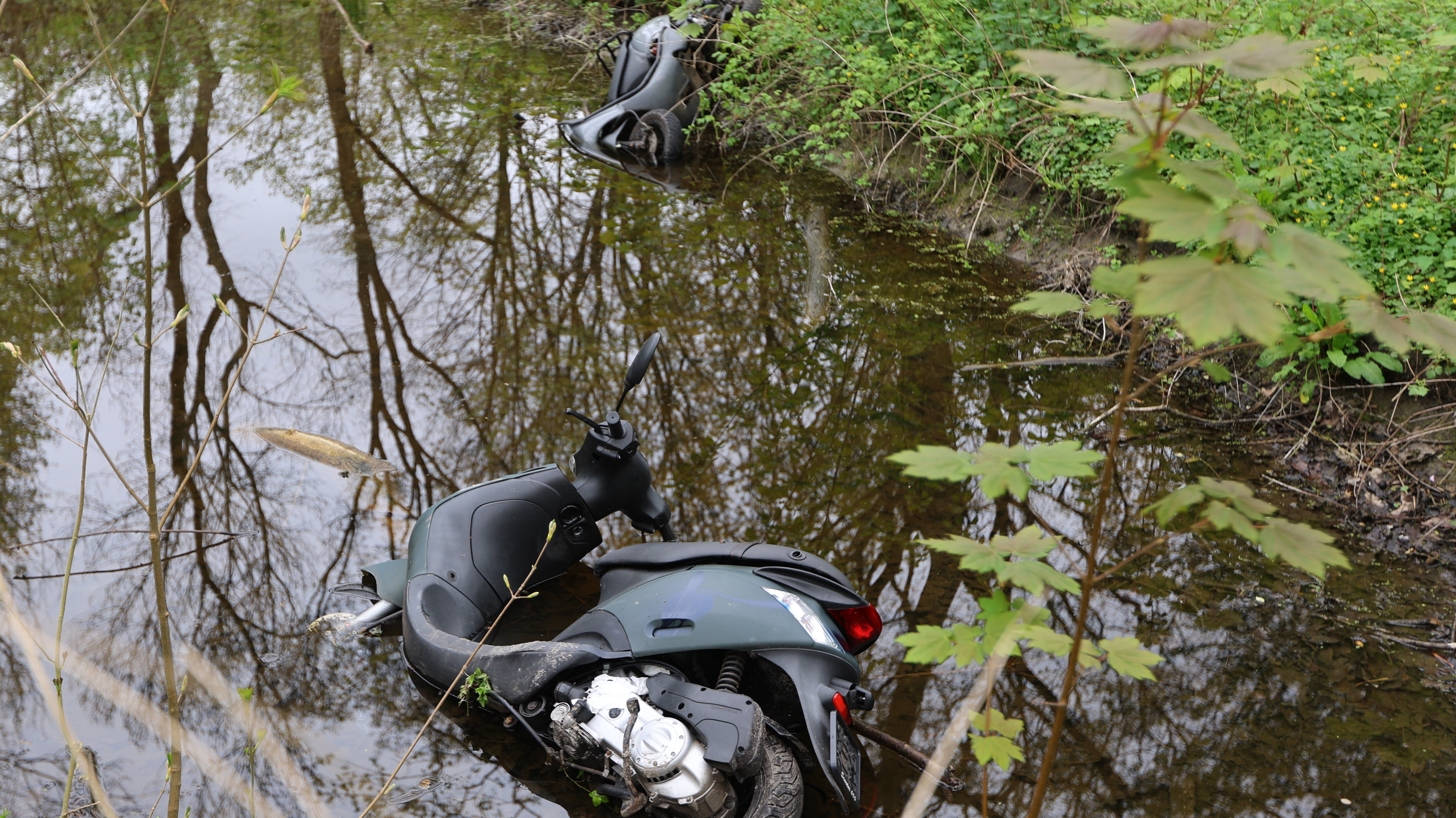 Twee scooters gedumpt in het water aan de John F. Kennedylaan