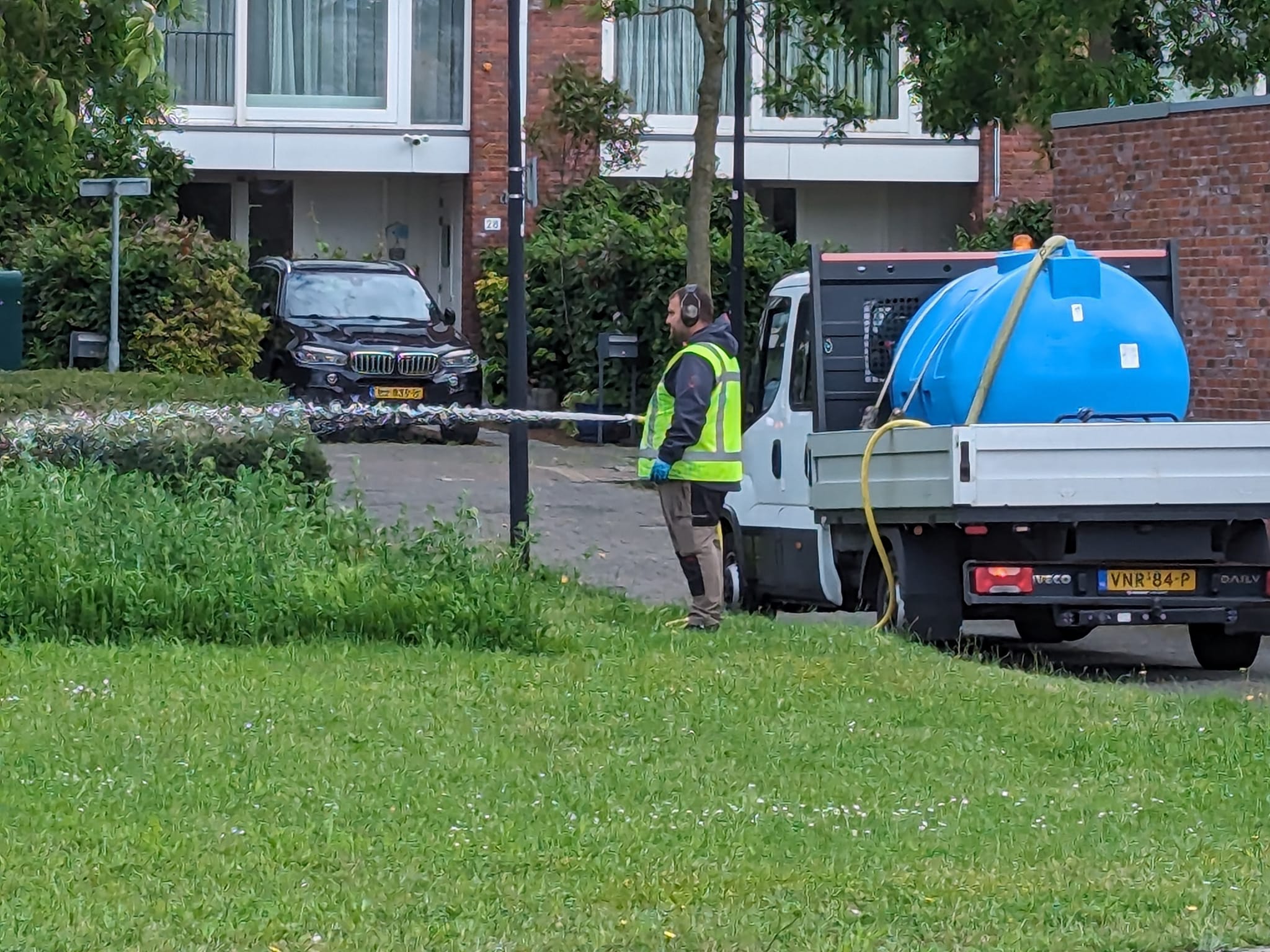 Gemeente Rijswijk geeft plantjes water op regenachtige dag