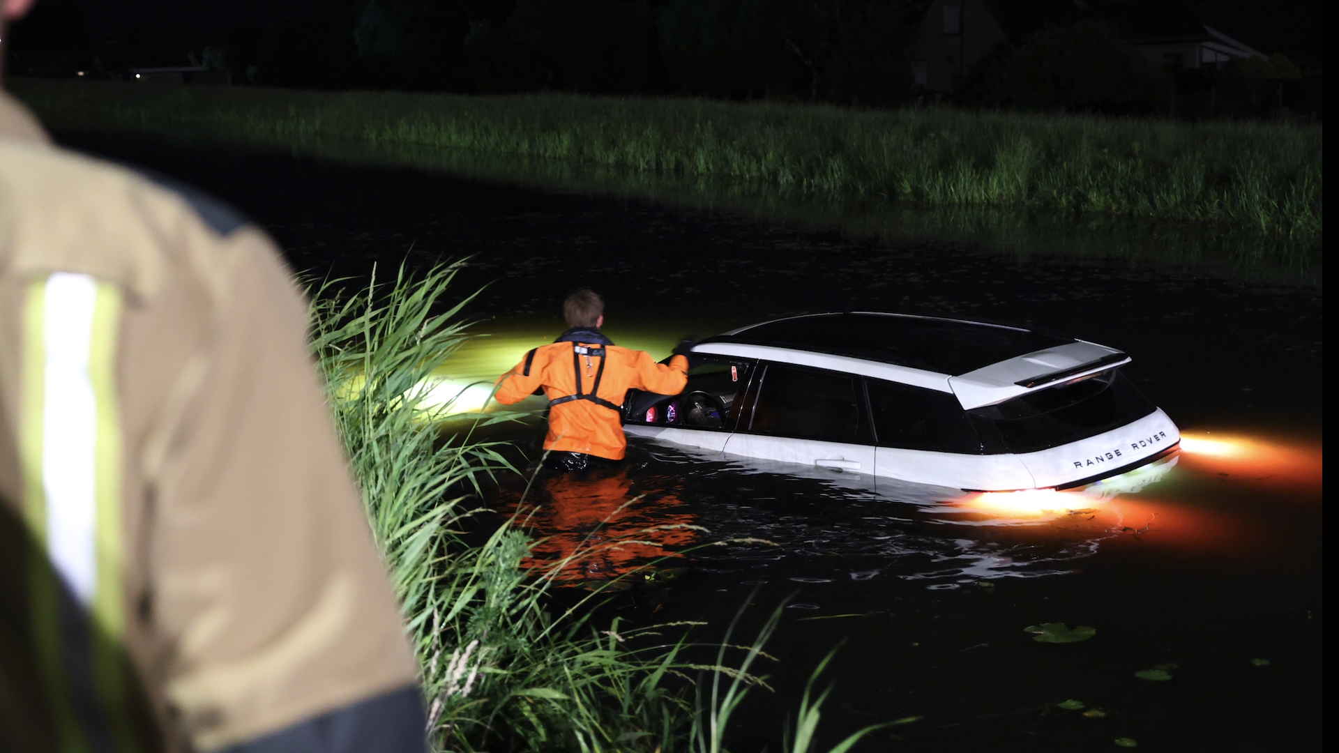 Automobilist moet uitwijken voor busje en belandt in water