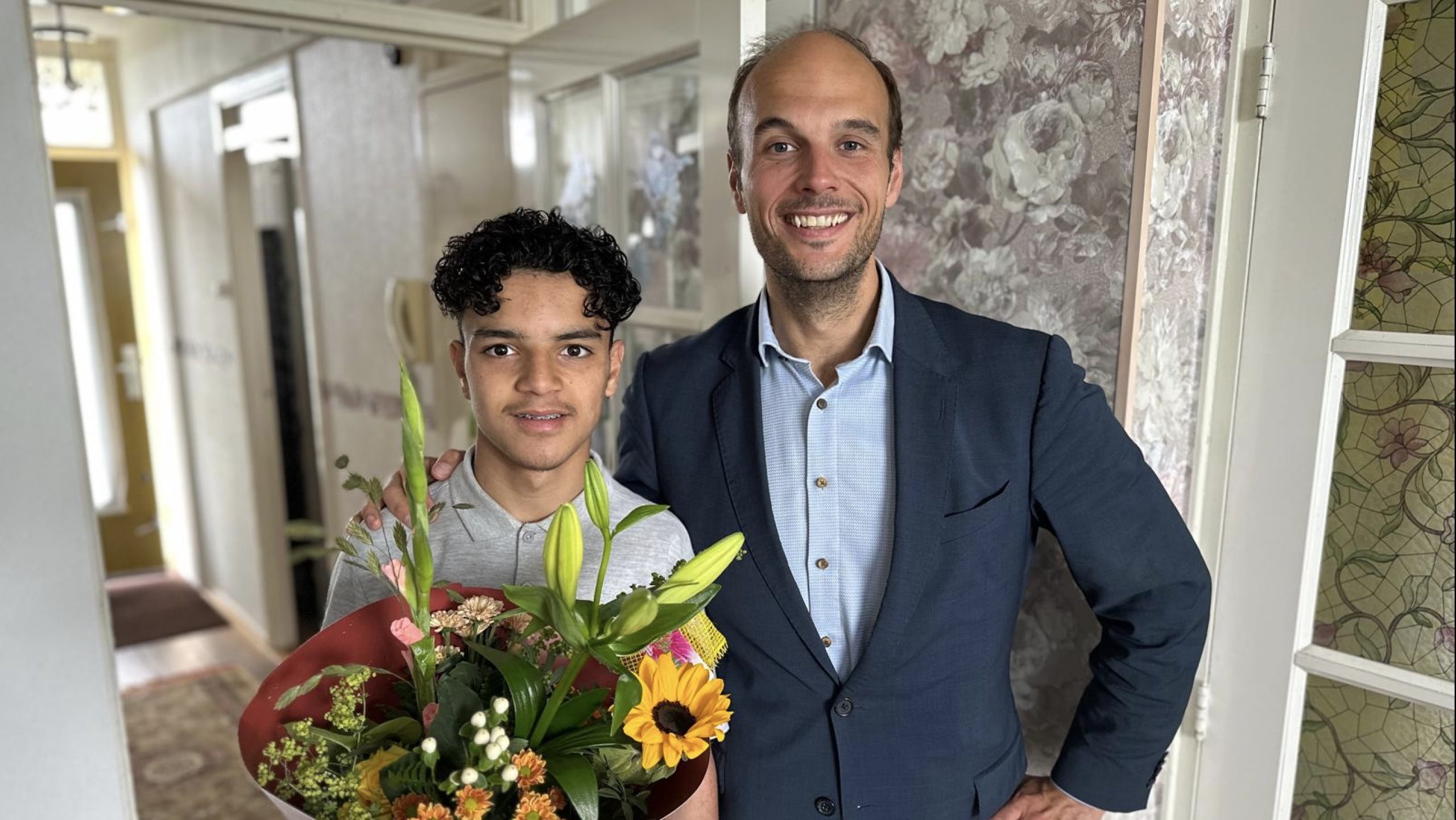 Wethouder verrast geslaagde leerling met bloemen