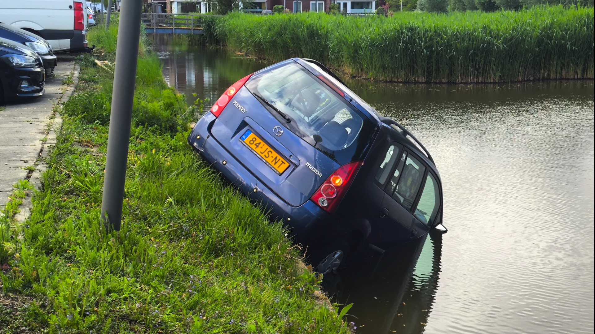 Auto rijdt het water van de Waddenzee in Nootdorp in